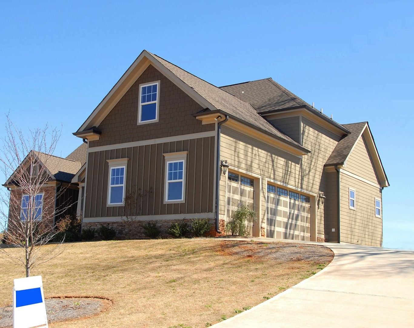 Cozy family home for sale in suburb with spacious garage and landscaped lawn.
